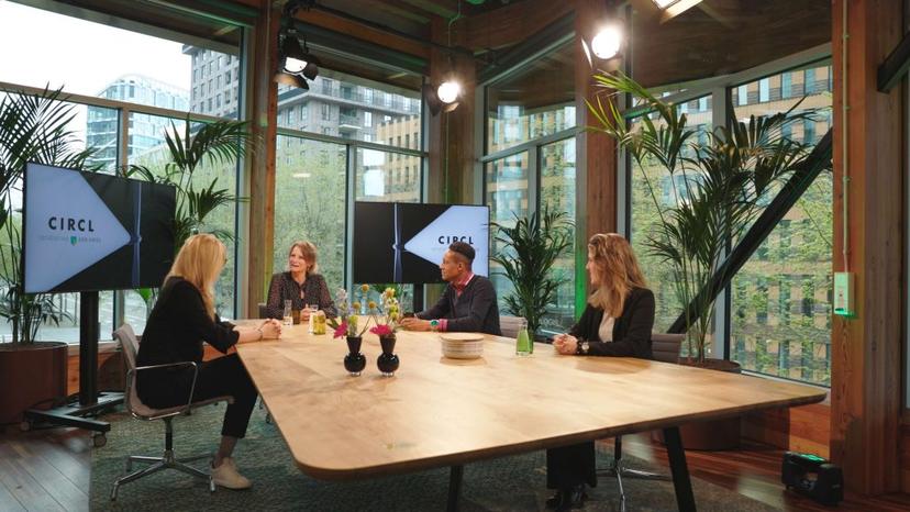Circl - afbeelding van vier mensen om een tafel, zo lijkt tijdens een tv uitzending of talkshow. Op de schermen staat Circl.